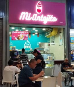 Vista de la heladería Mi Antojito con mesas y varias personas disfrutando de un rico helado