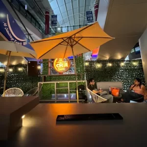 Vista general de Chiil Bar con mesas y toldos y pared con jardín vertical con una pareja disfrutando del ambiente