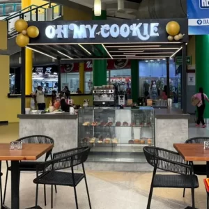 Góndola de postres Oh My Cookie en el Centro Comercial Metrópolis Barquisimeto, mostrando galletas, postres y área de café con mesas.