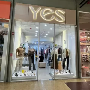 Fachada de la tienda de ropa YES en Metrópolis Barquisimeto, con maniquíes que muestran las últimas tendencias en ropa casual para damas y caballeros.